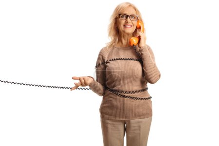 Photo for Mature woman wrapped in a cable making a call on a rotary phone isolated on white background - Royalty Free Image