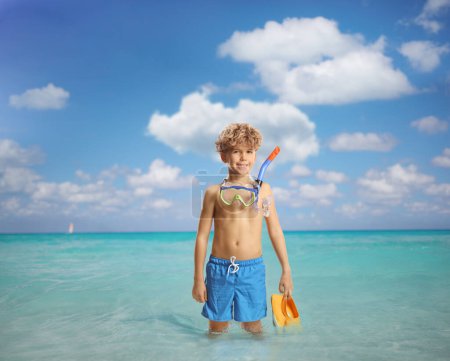 Foto de Niño con una máscara de buceo de pie dentro del azul del mar Caribe - Imagen libre de derechos