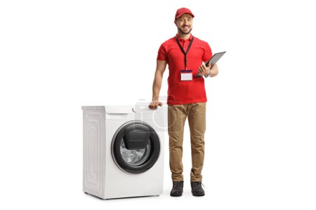 Téléchargez les photos : Portrait complet d'un vendeur masculin appuyé sur une machine à laver isolée sur fond blanc - en image libre de droit
