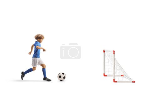 Téléchargez les photos : Plan complet du profil d'un garçon courant avec un ballon de football pour marquer un but isolé sur fond blanc - en image libre de droit