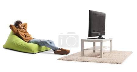 Photo for Guy sitting on a green cozy beanbag chair and watching tv isolated on white background - Royalty Free Image
