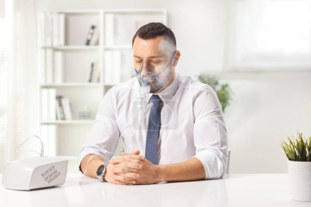 Téléchargez les photos : Homme d'affaires utilisant un nébuliseur avec brouillard de vapeur dans un bureau - en image libre de droit