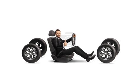 Photo for Elegant man in a suit behind a steering wheel gesturing thumbs up isolated on white background - Royalty Free Image