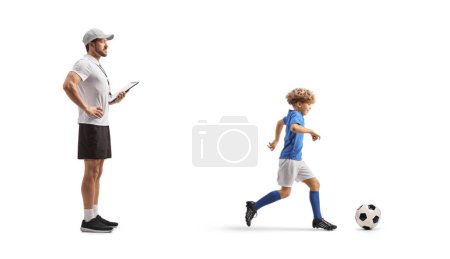 Téléchargez les photos : Coach regarder un garçon à l'entraînement de football isolé sur fond blanc - en image libre de droit