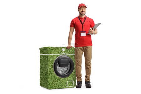Téléchargez les photos : Portrait complet d'un assistant de vente appuyé sur une machine à laver économe en énergie isolée sur fond blanc - en image libre de droit