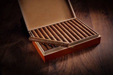Téléchargez les photos : Boîte de cigares cubains sur un sol en bois brun foncé - en image libre de droit