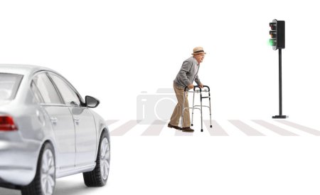 Photo for Full length profile shot of a senior with a walker crossing a street and car waiting at pedestrian isolated on white background - Royalty Free Image