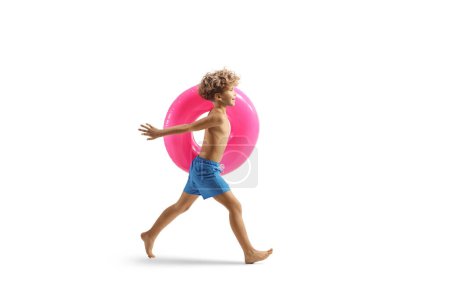 Téléchargez les photos : Garçon courir avec un anneau de natation en caoutchouc rose isolé sur fond blanc - en image libre de droit
