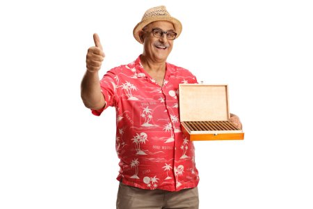 Téléchargez les photos : Touriste holing une boîte de cigares et geste pouces vers le haut isolé sur fond blanc - en image libre de droit