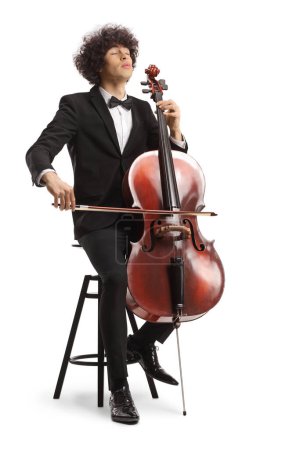 Photo for Young male artist sitting on a chair and playing a cello with closed eyes isolated on white background - Royalty Free Image