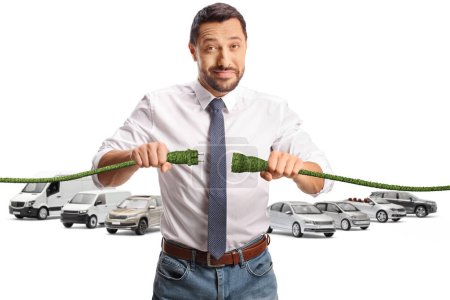 Foto de Hombre sosteniendo cables verdes frente a vehículos estacionados aislados sobre fondo blanco - Imagen libre de derechos