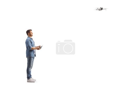 Téléchargez les photos : Homme pilotant un drone avec un contrôleur isolé sur fond blanc - en image libre de droit