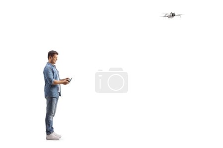 Photo for Man flying a drone and looking at the remote cotroller isolated on white background - Royalty Free Image