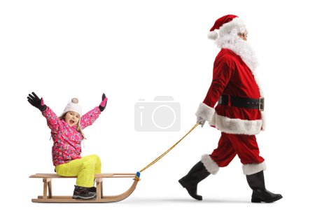 Foto de Santa Claus tirando de un trineo de madera con una niña feliz aislada sobre fondo blanco - Imagen libre de derechos