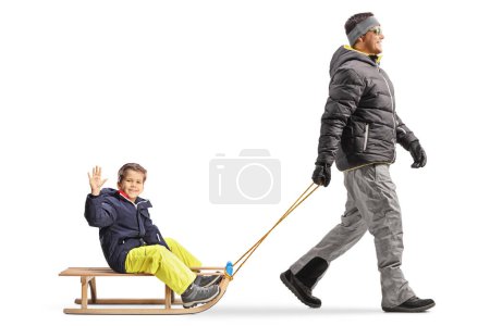 Téléchargez les photos : Père tirant son fils sur un traîneau en bois isolé sur fond blanc - en image libre de droit