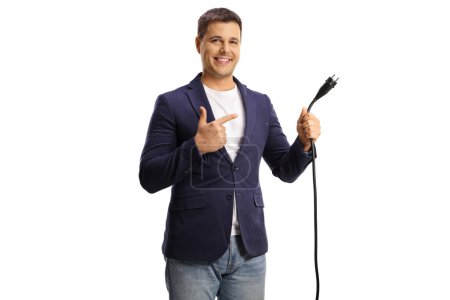 Foto de Hombre sosteniendo un cable eléctrico con un enchufe y apuntando aislado sobre fondo blanco - Imagen libre de derechos