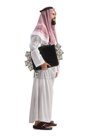 Téléchargez les photos : Plan de profil complet d'un homme arabe suadi avec une mallette pleine d'argent isolé sur fond blanc - en image libre de droit