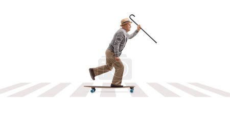 Photo for Full length profile shot of a grandpa riding a longboard on a pedestrian crossing isolated on white background - Royalty Free Image
