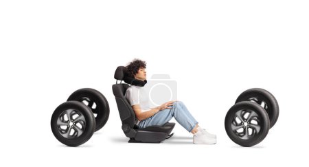 Photo for Guy in a car seat on four tires with a travel pillow around neck isolated on white background - Royalty Free Image