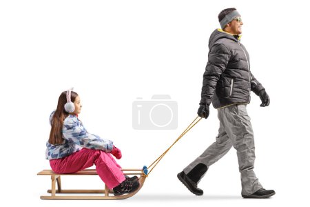 Téléchargez les photos : Homme tirant une fille sur un traîneau en bois isolé sur fond blanc - en image libre de droit