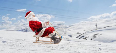 Foto de Santa Claus deslizándose en un trineo de madera en una montaña con nieve - Imagen libre de derechos