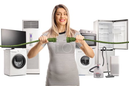 Photo for Happy young woman with green cables in front of electric appliances isolated on white background - Royalty Free Image