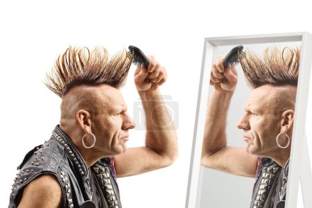 Photo for Man combing his mohawk hairstyle with a brush in front of a mirror isolated on white background - Royalty Free Image