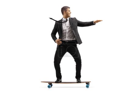 Foto de Empresario con traje negro montado en un monopatín aislado sobre fondo blanco - Imagen libre de derechos