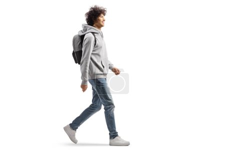 Foto de Perfil de cuerpo entero de un estudiante caucásico caminando y sonriendo aislado sobre fondo blanco - Imagen libre de derechos