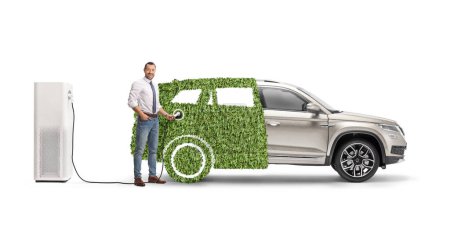Téléchargez les photos : Homme d'affaires charge son véhicule hybride vert isolé sur fond blanc - en image libre de droit