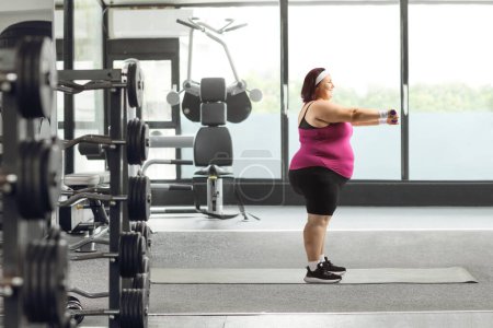 Téléchargez les photos : Femme faisant de l'exercice avec haltères dans une salle de gym, exercice et concept de perte de poids - en image libre de droit