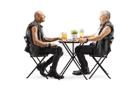 Foto de Hombres en chalecos de cuero sentados a la mesa y con cerveza aislada sobre fondo blanco - Imagen libre de derechos