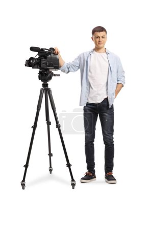 Foto de Retrato de cuerpo entero de un joven operador de cámara con una cámara sobre un trípode aislado sobre fondo blanco - Imagen libre de derechos