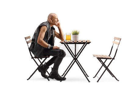 Foto de Hombre sentado a una mesa solo con una pinta de cerveza aislada sobre fondo blanco - Imagen libre de derechos