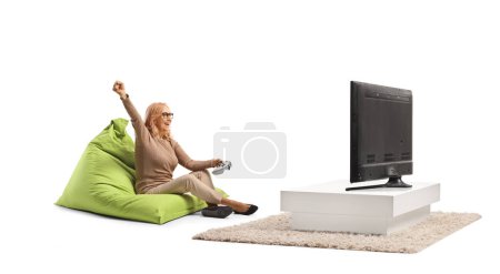 Foto de Mujer de mediana edad jugando videojuegos frente a la televisión aislado sobre fondo blanco - Imagen libre de derechos