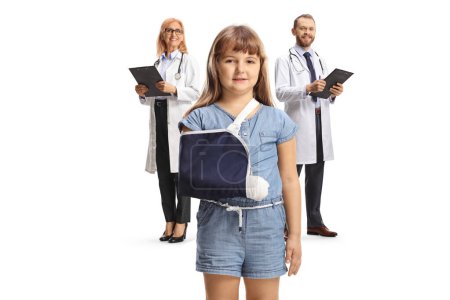 Téléchargez les photos : Médecins et une fille avec un bras cassé portant une fronde isolée sur fond blanc - en image libre de droit