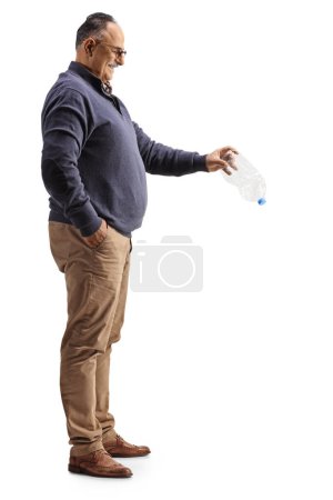 Téléchargez les photos : Photo de profil pleine longueur d'un homme mûr tenant une bouteille en plastique vide isolée sur fond blanc - en image libre de droit