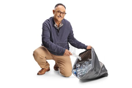 Téléchargez les photos : Homme mûr collectant des bouteilles en plastique dans un sac à déchets isolé sur fond blanc - en image libre de droit