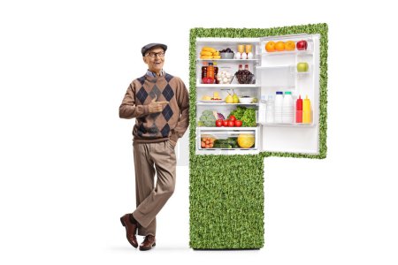 Téléchargez les photos : Portrait complet d'une personne âgée pointant vers un réfrigérateur économe en énergie isolé sur fond blanc - en image libre de droit