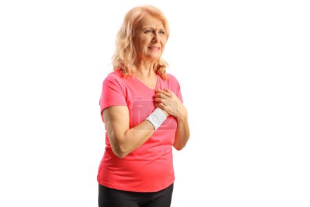 Photo for Middle aged woman in sportswear experiencing chest pain isolated on white background - Royalty Free Image