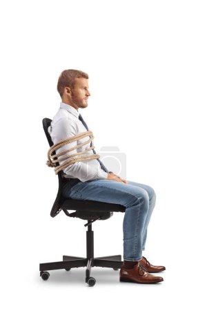Foto de Foto de perfil de un oficinista atado a una silla con una cuerda aislada sobre fondo blanco - Imagen libre de derechos