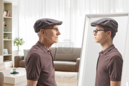 Téléchargez les photos : Homme plus âgé regardant un miroir et se souvenant quand il était jeune - en image libre de droit