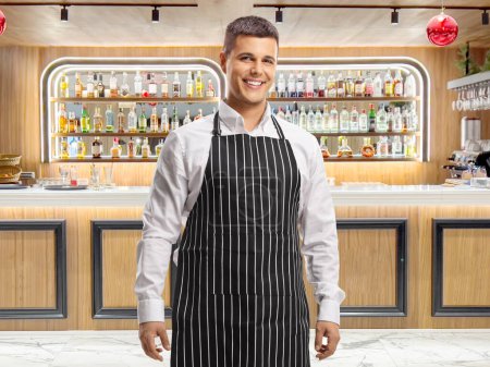 Photo for Caterer wearing an apron at a bar - Royalty Free Image