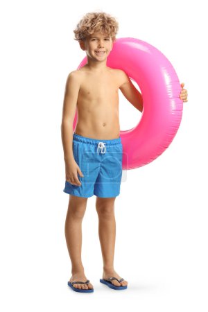 Foto de Niño de pie con un anillo de natación de goma rosa aislado sobre fondo blanco - Imagen libre de derechos
