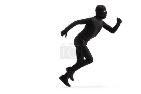 Téléchargez les photos : Plan de profil complet d'un voleur vêtu de noir et de cagoule isolé sur fond blanc - en image libre de droit