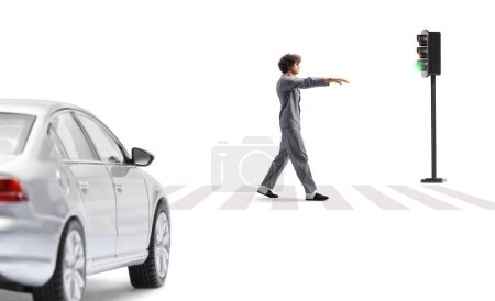 Full length profile shot of a guy in pajamas sleepwalking on a street in front of a vehicle isolated on white background