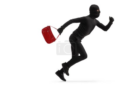Téléchargez les photos : Photo de profil pleine longueur d'un voleur déguisé courant avec un sac volé isolé sur fond blanc - en image libre de droit