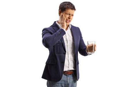 Téléchargez les photos : Homme tenant un verre d'eau et ayant un mal de dents isolé sur fond blanc - en image libre de droit