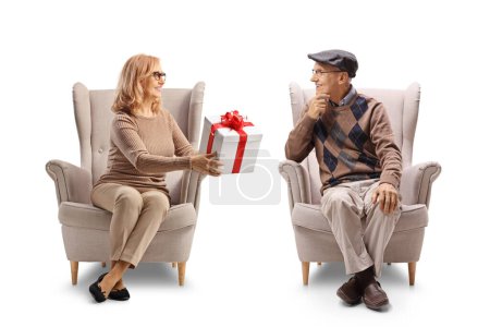 Foto de Mujer sentada en un sillón y regalando a un anciano aislado sobre fondo blanco - Imagen libre de derechos