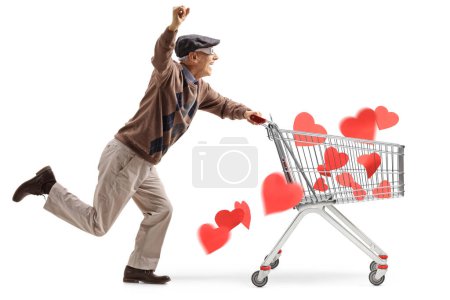 Foto de Senior con gafas 3D corriendo y empujando un carrito de compras con corazones rojos aislados sobre fondo blanco - Imagen libre de derechos